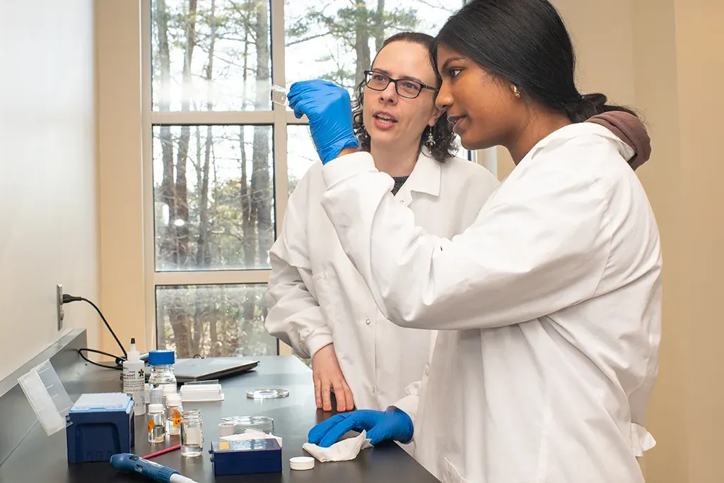 Two students looking at a microscope slide